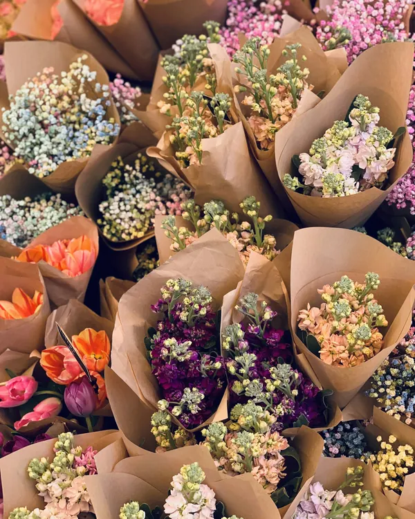 Des dizaines de petits bouquets emballés dans du papier kraft, prêts à partir